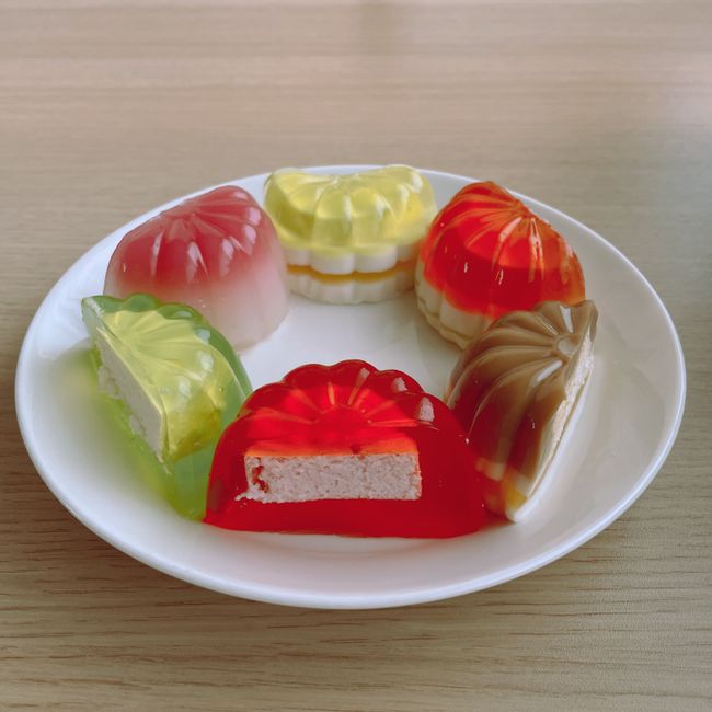 赤・黄・緑・オレンジなど色とりどりの琥珀糖風ゼリー菓子を白い皿に盛り合わせた様子