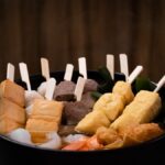 串打ちされたおでん種が煮える黒い土鍋
