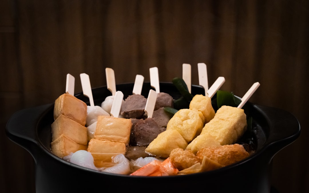 串打ちされたおでん種が煮える黒い土鍋