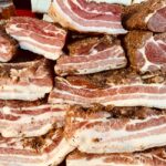 スパイスをまぶして積み重ねた生の豚バラ肉スライス