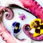 花を添えて白い皿に盛り付けたたこの足