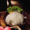 生の牛の蜂の巣状の内臓とレタスを盛り付けた皿