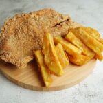 木の皿にのせた揚げ鶏とフライドポテト