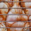 網越しに見える下味をつけた生の鶏もも肉