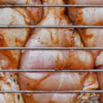 網越しに見える下味をつけた生の鶏もも肉