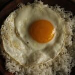 黒い器に盛ったご飯と目玉焼き