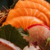 笹の葉と一緒に盛り付けられた刺身の盛り合わせのクローズアップ