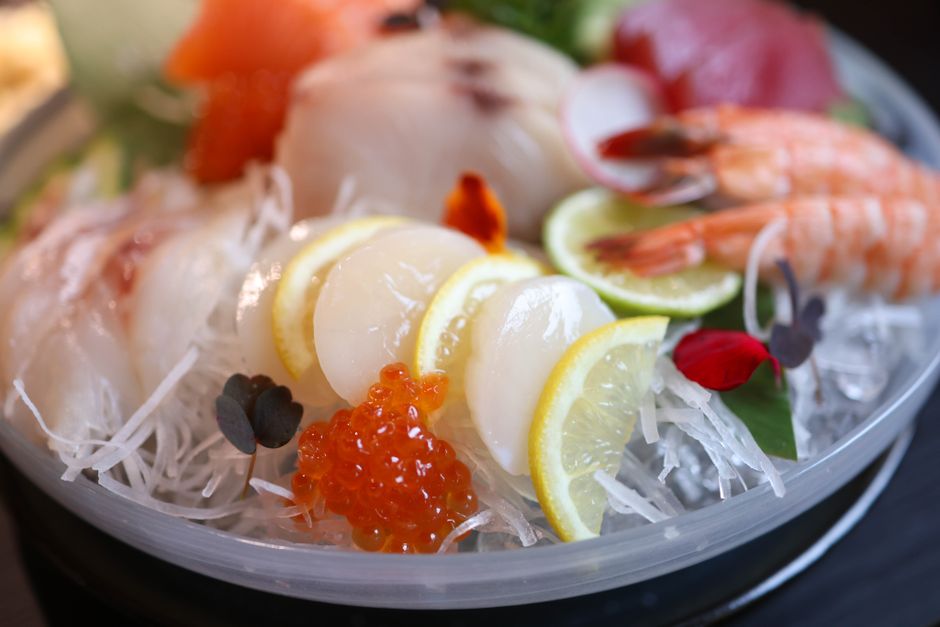 木の器に盛られたサーモンやまぐろの刺身盛り合わせ