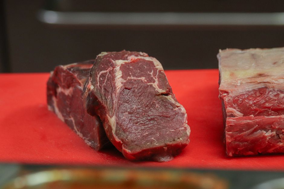 赤いまな板に並んだ生の牛肉の塊