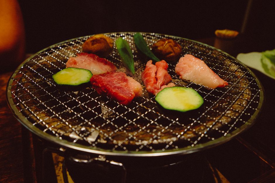 焼肉用の七輪で牛肉と野菜を焼いている様子