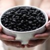 黒豆を盛った白い器を両手で持つ様子