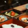 朱色の重箱に品目ごとに詰められた料理