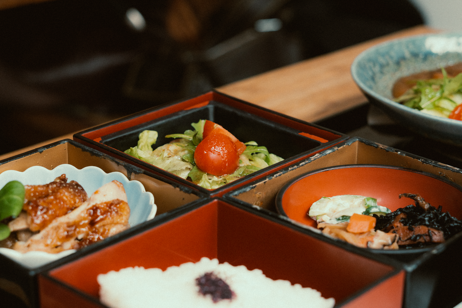 朱色の重箱に品目ごとに詰められた料理