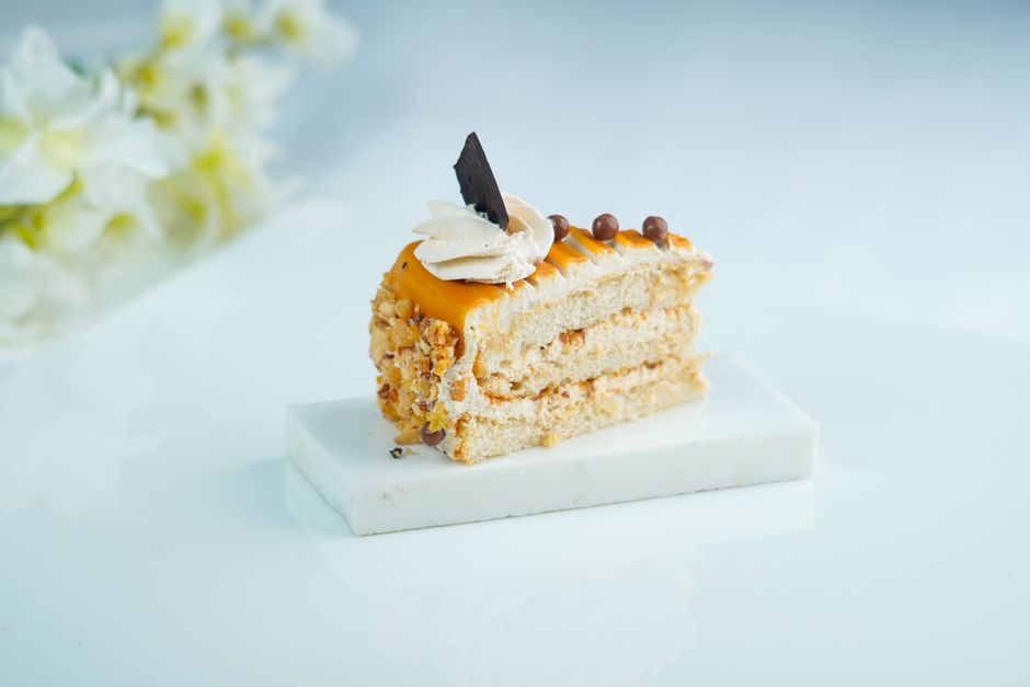 白い皿にのせた茶色いスポンジケーキのひと切れ