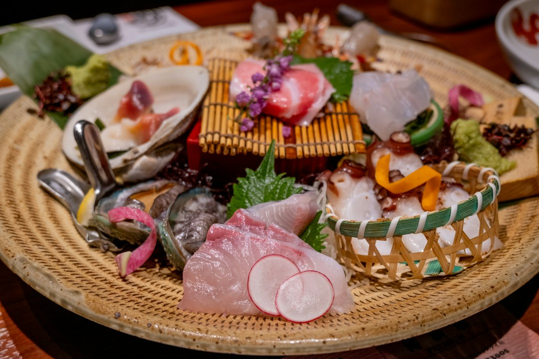 竹かごの皿に盛り付けた刺身の盛り合わせ