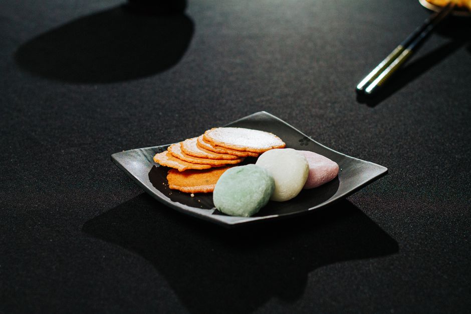 黒い皿に盛った大福と干菓子の盛り合わせ