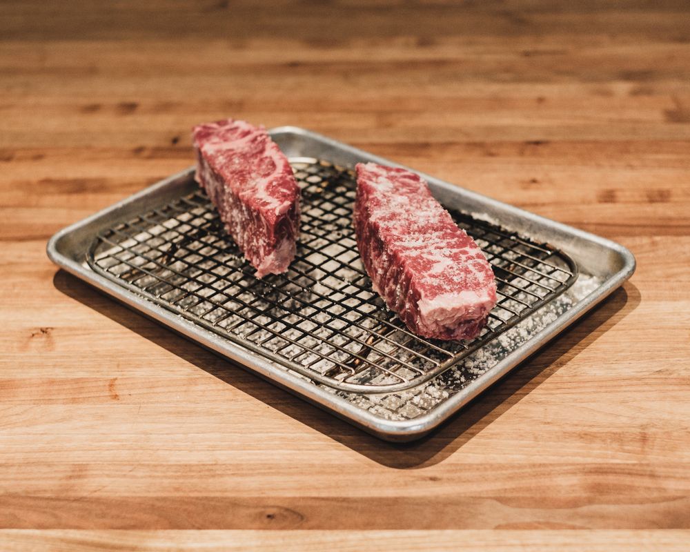 網の上に置かれた2切れの霜降り牛肉の塊
