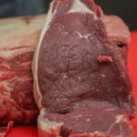 まな板に置かれた牛肉の赤身ブロックと切り分けた断面