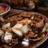 豚肉と白菜を甘辛い黒いソースで炒めた中華料理のクローズアップ