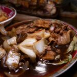 豚肉と白菜を甘辛い黒いソースで炒めた中華料理のクローズアップ