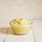 ガラスの器に入った淡い黄色のペースト状食品