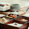 漆器の重箱に盛られた和食料理とお茶のセット