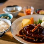 ごはんと小鉢が並ぶ定食スタイルで盛り付けたデミグラスソースのハンバーグ