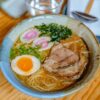 水色の器に盛った醤油ラーメンとチャーシュー、半熟卵、なると