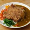 揚げたてとんかつにカレーソースを添えた一皿