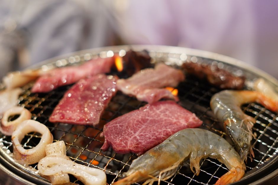 焼肉グリルで一緒に焼く牛肉とエビ、イカ