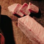 木の台の上に並べられた霜降り牛肉のスライス