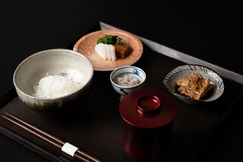 お膳に並んだご飯と小鉢、箸置きの和食セット