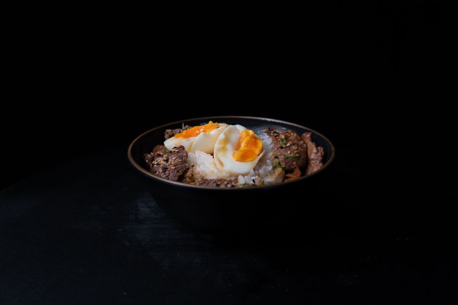 黒い器に盛られた牛丼と半熟卵