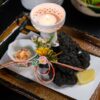 黒いトレーに小皿を並べた和食の膳