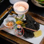 黒いトレーに小皿を並べた和食の膳